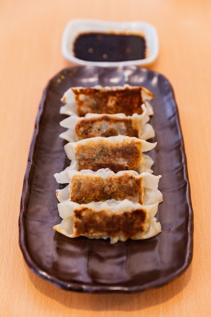 Gyoza (Dumplings japonais poêlés) servis avec sauce et huile de sésame.