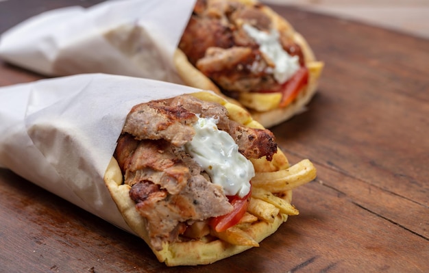 Gyro pita shawarma à emporter de la nourriture de rue Cuisine de viande turque traditionnelle grecque sur table en bois