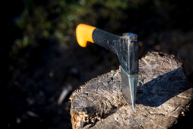 Une hache en acier pointue coincée dans un billot