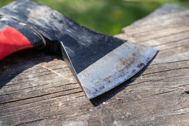 Une hache tranchante avec une poignée caoutchoutée ergonomique sur un fond en bois La hache est destinée aux rugueux