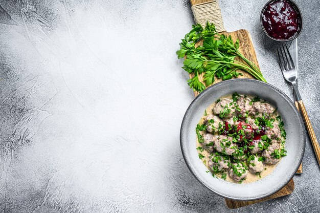 Hacher les boulettes de viande avec une sauce à la crème sur une assiette.