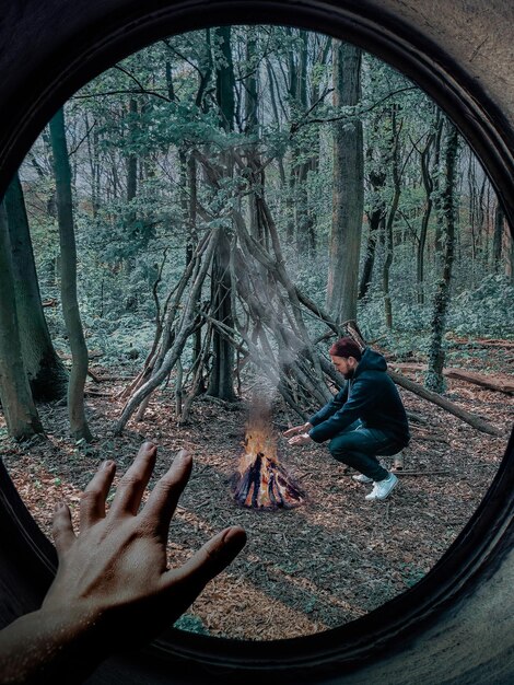 Haciendo fuego en el bosque dentro de un espejo