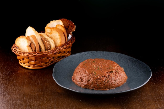 Hackepeter plat allemand de viande crue assaisonnée de corbeille à pain vue sur table en bois