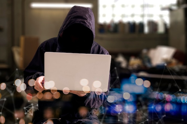 Photo un hacker anonyme dans le capot avec un ordinateur, une rupture d'informations numériques