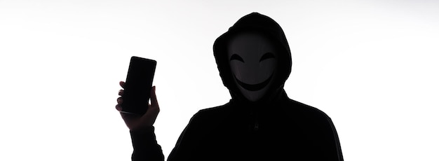 Hacker Anonymous et masque facial avec smartphone à la main