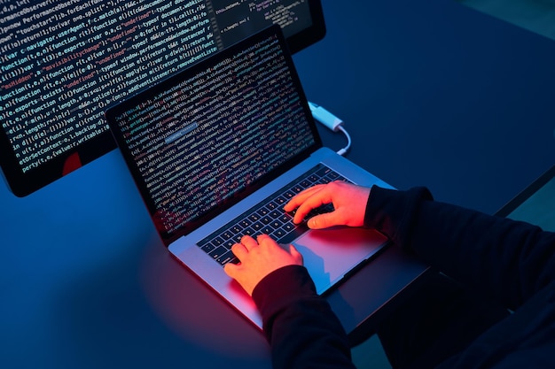 Hacker de guerre informatique brisant la sécurité personne anonyme accès à des données sensibles codage d'attaque informatique