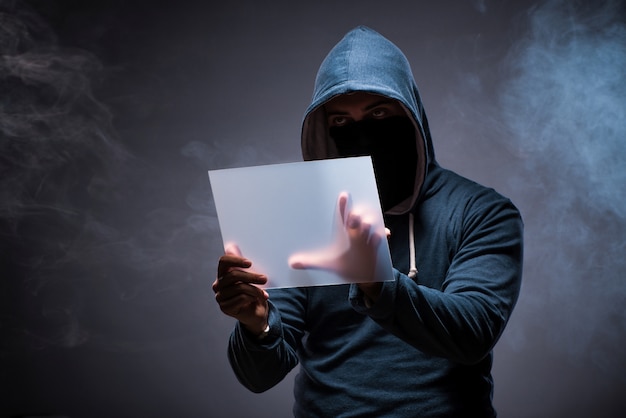 Hacker travaillant sur une tablette dans le noir