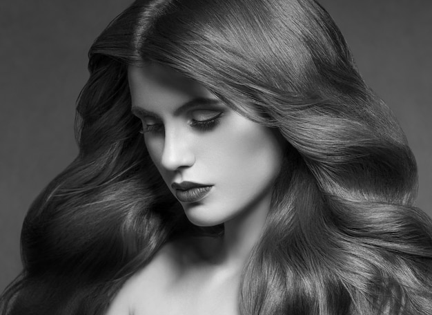 Hairte coiffure modèle beauté femme brune longue bouclée. Prise de vue en studio.