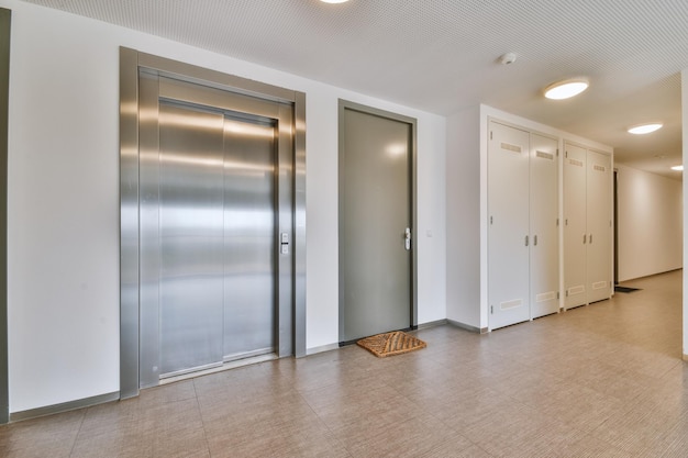Hall d'entrée d'un immeuble résidentiel moderne avec ascenseur et garde-robe sur un sol carrelé