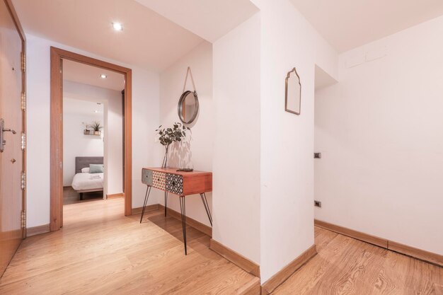 Hall d'entrée d'une maison avec un buffet en bois orange à tiroirs polychromes et accès à une chambre et à d'autres pièces