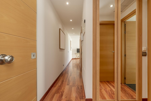 Hall d'entrée d'une maison avec un long couloir avec placards