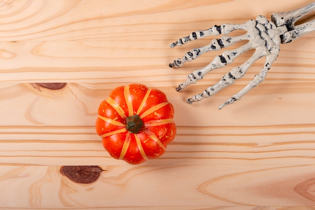 Photo halloween et concept de décoration. squelette cueillette de citrouille sur fond en bois.