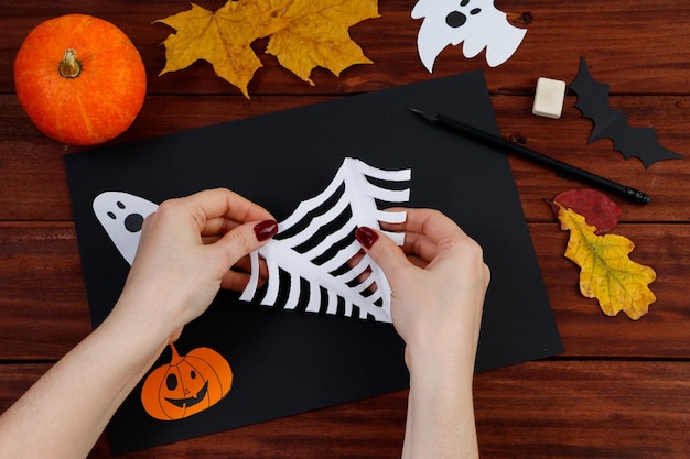 Halloween DIY Instructions étape par étape pour couper une toile d'araignée dans du papier pour les vacances