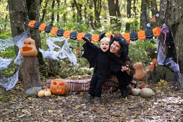 Halloween. Mère avec petit fils en costumes d'halloween s'amusant en plein air