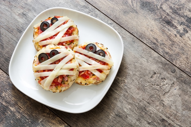 Halloween momies mini pizzas sur table en bois copie espace