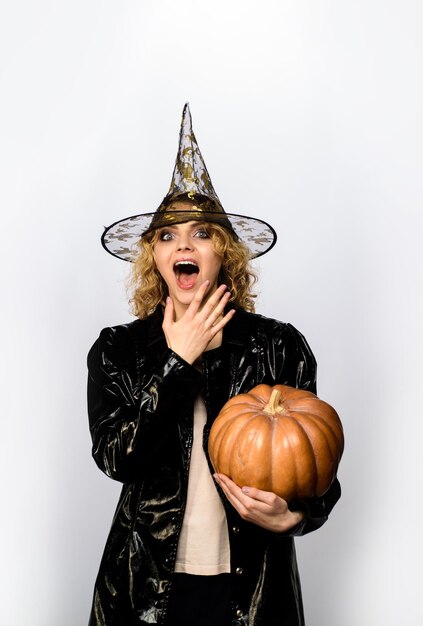 Halloween vacances octobre femme au chapeau de sorcière avec citrouille femme heureuse en costume d'halloween de sorcière