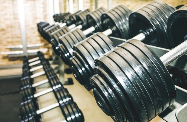 Des haltères lourds se trouvant à l'état brut dans la salle de gym. Motivation sportive de remise en forme. Heureux mode de vie sain. Exercices avec des barres de poids.