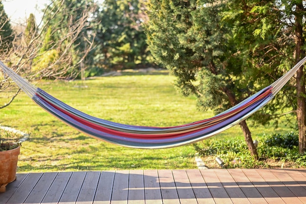 Hamac coloré confortable à l'extérieur par beau temps sur la terrasse de la maison