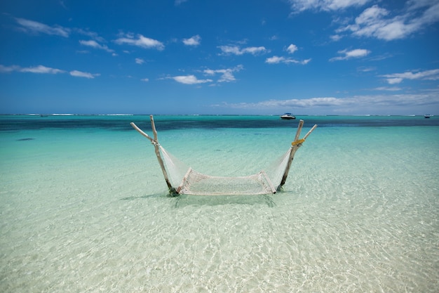 Hamac sur pilotis vide au milieu du lagon tropical