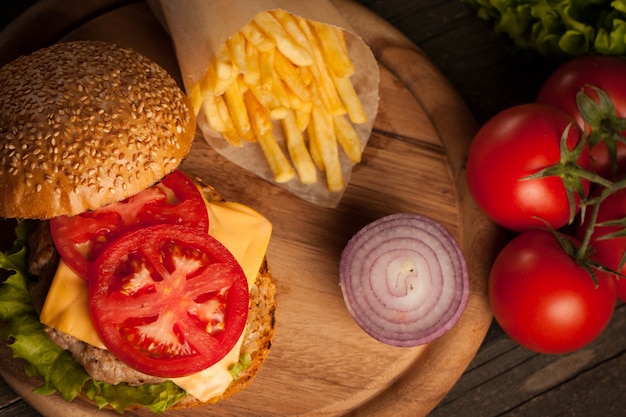 Hamburger au bœuf, à l'oignon, à la tomate, à la laitue et au fromage.