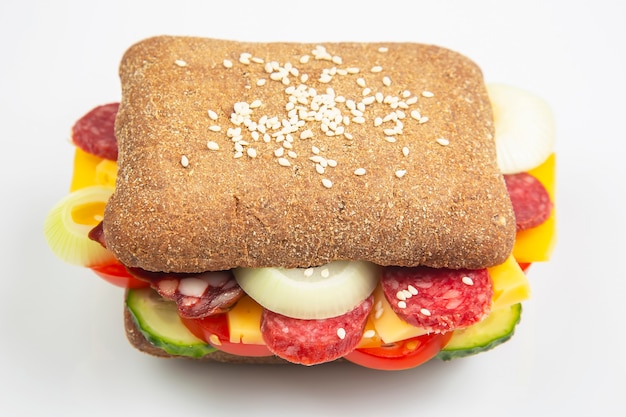 Hamburger aux légumes et saucisses sur une surface blanche. Restauration rapide et petit déjeuner. Calories et régime.