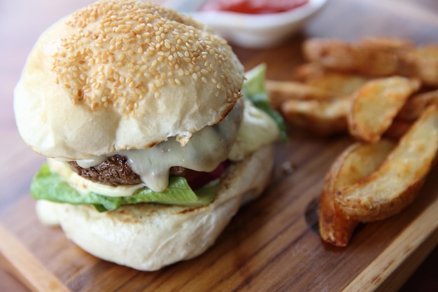 Hamburger de boeuf au fromage et feux sur fond de bois