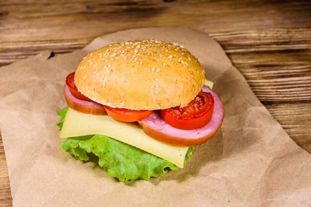 Hamburger frais sur papier brun sur une table en bois rustique