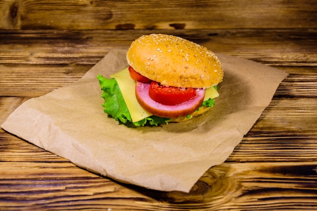 Hamburger frais sur papier brun sur table en bois