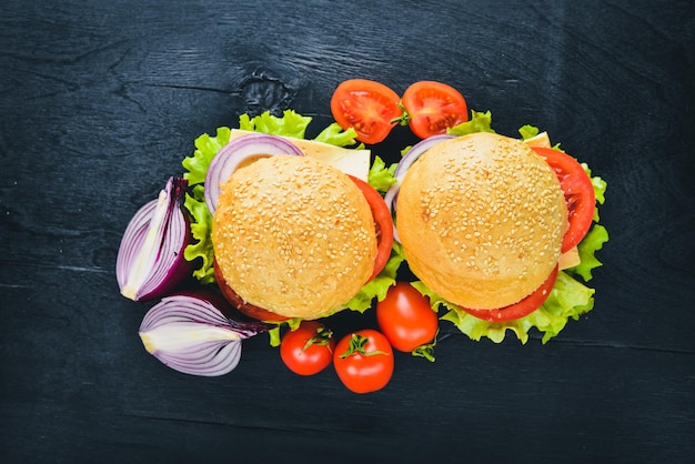 Hamburger avec fromage viande tomates et oignons et herbes sur fond de bois Vue de dessus Espace libre