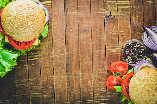 Hamburger avec fromage viande tomates et oignons et herbes sur fond de bois Vue de dessus Espace libre