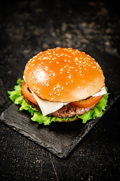 Un hamburger sur une planche en pierre sur une table