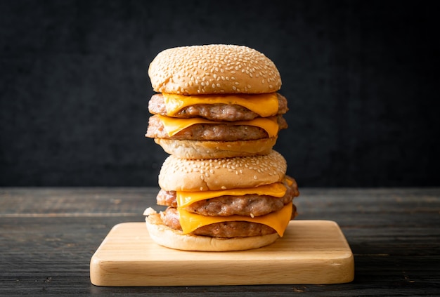 Hamburger de porc ou burger de porc avec du fromage sur planche de bois