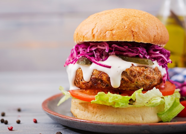 Hamburger sandwich avec hamburgers juteux, tomate et chou rouge