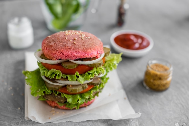 Hamburger savoureux avec de la viande et des légumes sur un fond sombre. Fast food. Il peut être utilisé comme arrière-plan