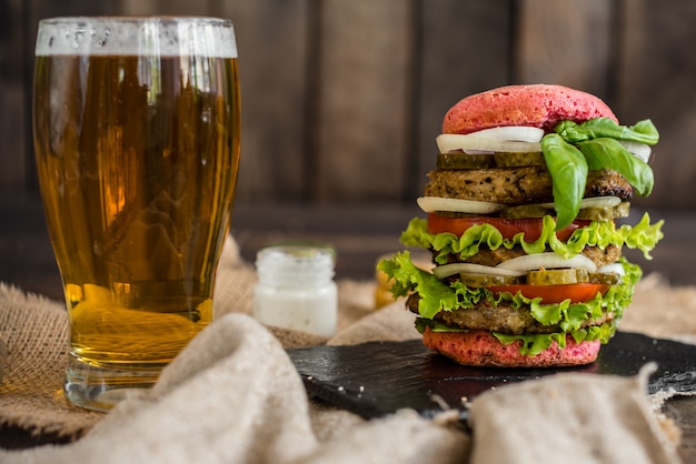 Hamburger savoureux avec de la viande et des légumes sur un fond sombre. Fast food. Il peut être utilisé comme arrière-plan