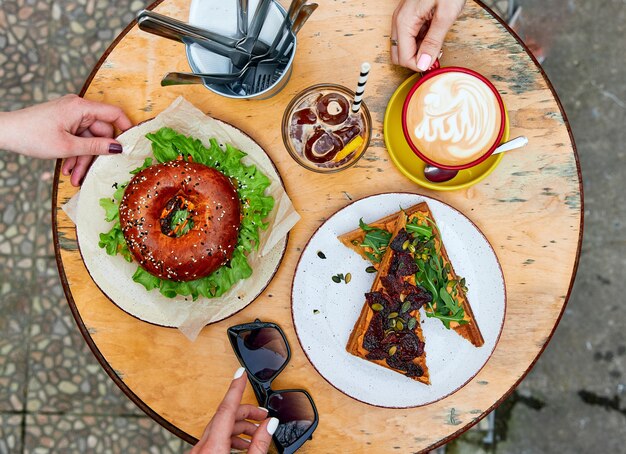 Hamburger sous la forme d'un café sandwichs dout beaucoup de nourriture sur une table en bois