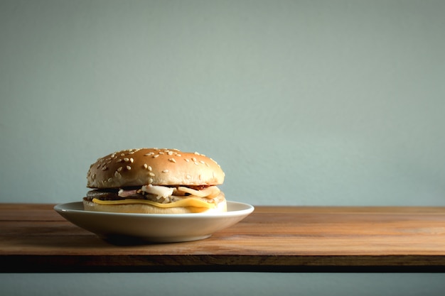 Hamburger sur table en bois avec espace copie et fond de mur blanc.