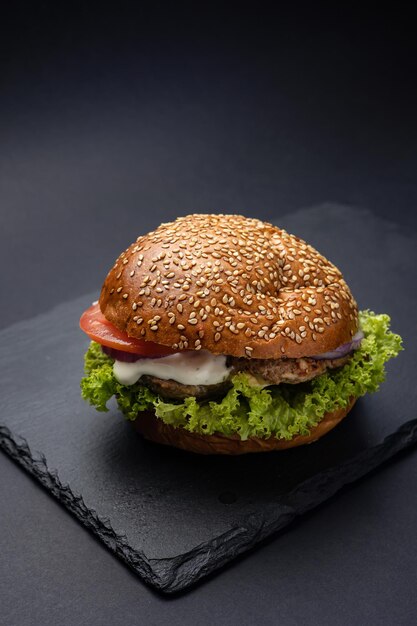 Hamburger sur un tableau noir sur un fond en bois noir