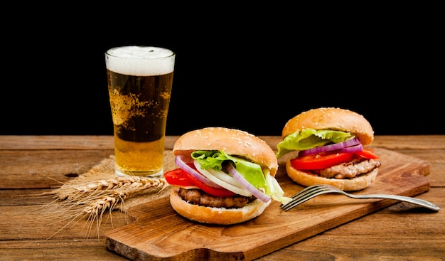 hamburger avec une tasse de bière sur la table en bois