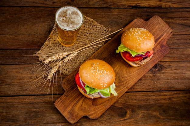 hamburger avec une tasse de bière sur la table en bois