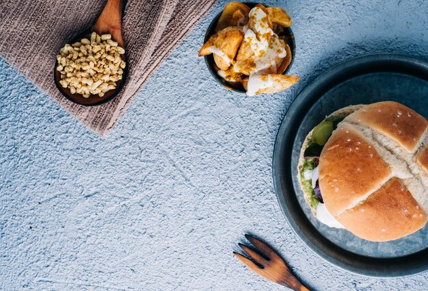 Hamburger végétalien aux protéines de soja avec frites aux épices dans un bol en métal. copier l'espace. vue de dessus