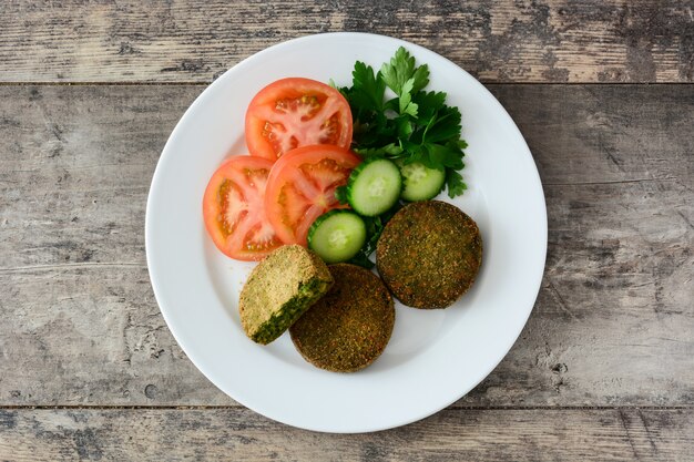 Hamburger végétarien grillé aux épinards et petits pois avec salade sur plaque blanche sur table en bois Vue de dessus