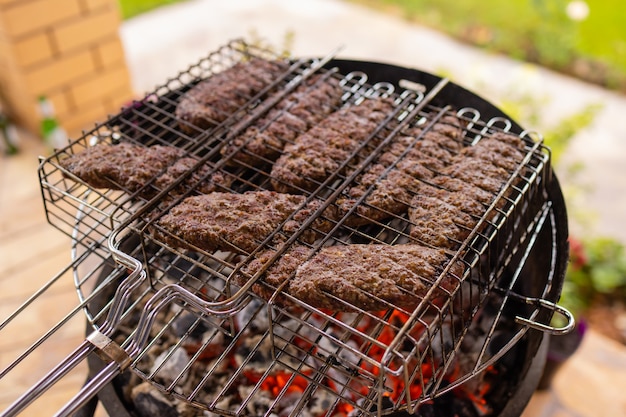 Hamburgers cuisant sur le gril, copiez l'espace.