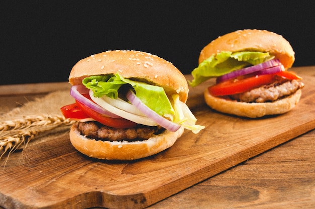 Photo hamburgers délicieux sur fond en bois.