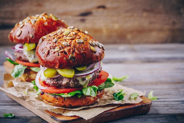 Des hamburgers faits maison avec pain de grains entiers sur un fond de bois