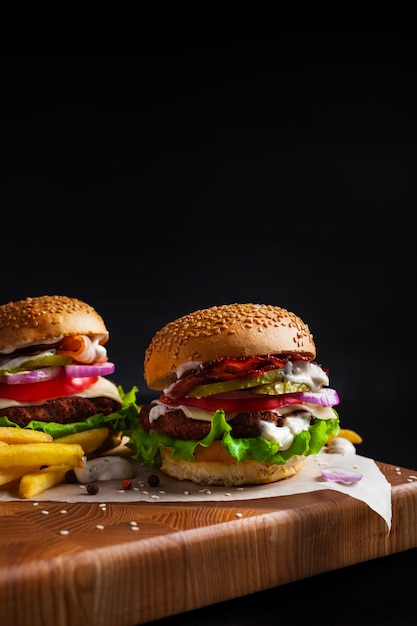 Hamburgers faits maison sur un tableau noir sur fond noir