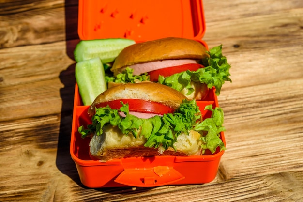 Hamburgers avec laitue en boîte à lunch sur table en bois rustique