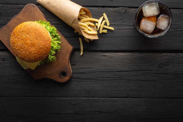Des hamburgers savoureux frais avec des frites, boire sur la vue de dessus de table en bois.