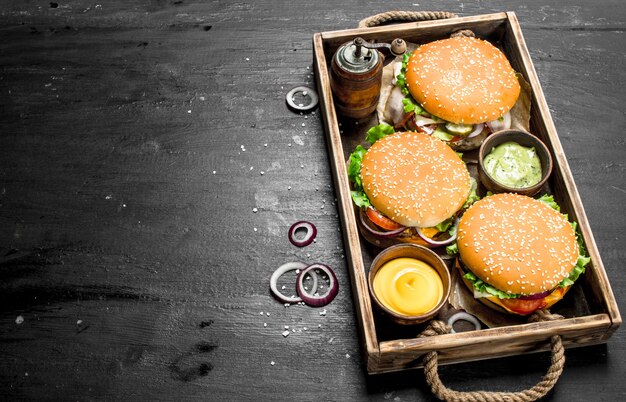 Des hamburgers sur un vieux plateau sur le tableau noir