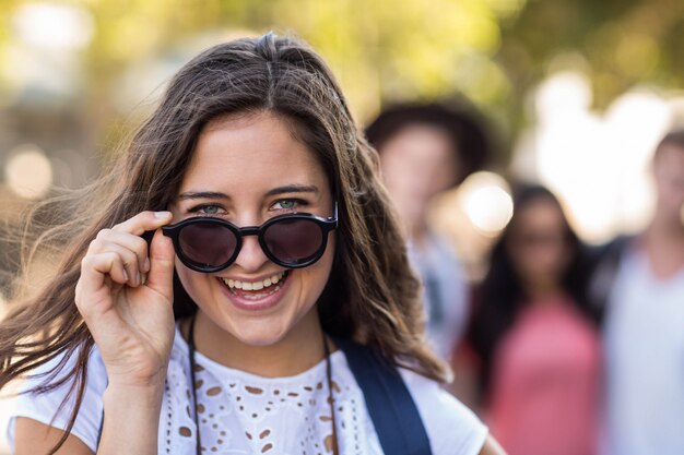 Hanche femme avec des lunettes de soleil souriant à la caméra